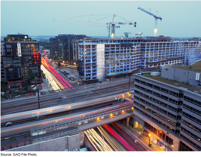 Cranes, high rise buildings, roads, and elevated train tracks