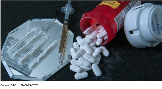 Photo illustration of lines of cocaine, a syringe, and pills spilling out of a bottle.  