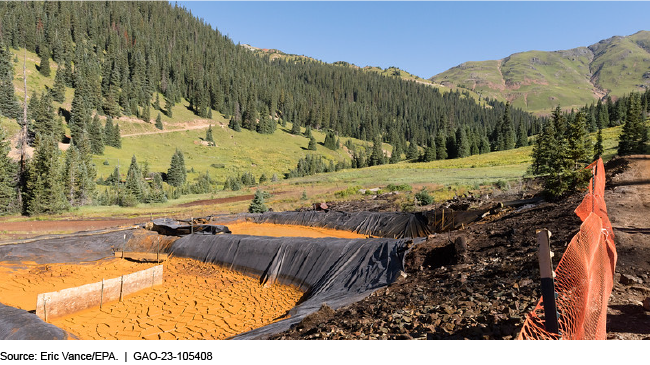 A picture of two mine pits surrounded by trees and hills