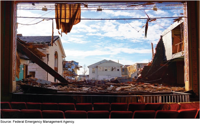 Damaged buildings and debris as viewed from a theater whose exterior wall was destroyed