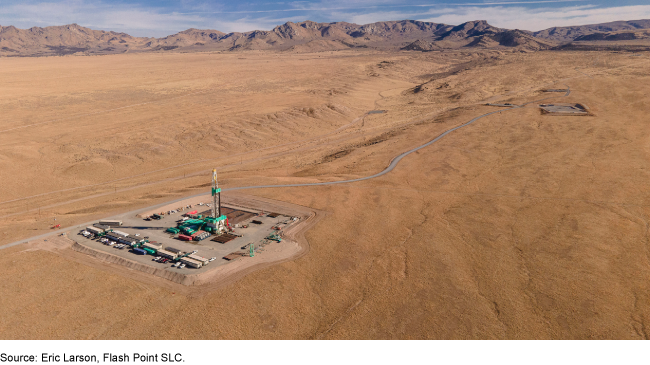 A collection of buildings in the middle of a desert with mountains in the background. A collection of buildings in the middle of a desert with mountains in the background.