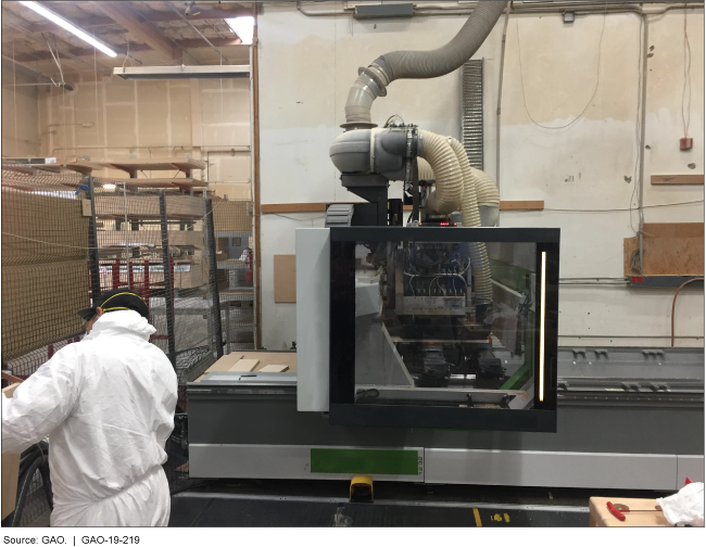 A machine and nearby worker in a cabinet manufacturing facility