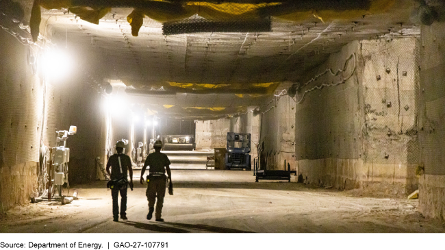 Two workers walk in an underground salt mine.