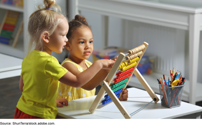 Two young children use an abacus in a preschool classroom.