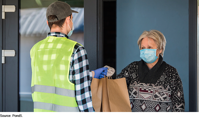 A courier handing bags to a customer