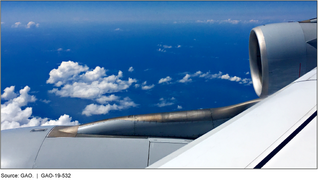Photo overlooking the wing of an airplane flying over an ocean