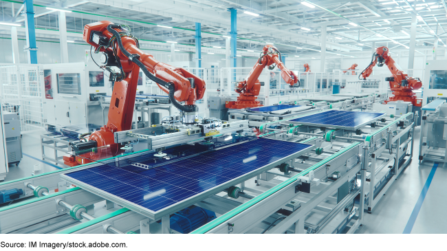 Robotic arms making solar panels in a factory setting. 