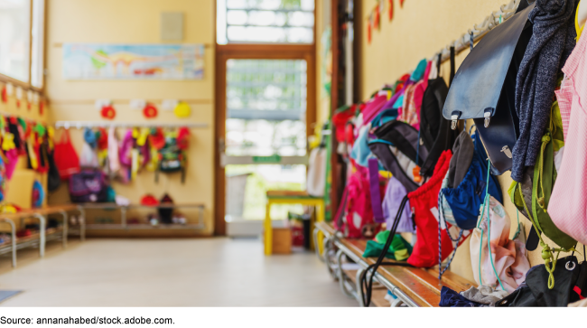 Empty hallway with backpacks hanging on hooks on the wall