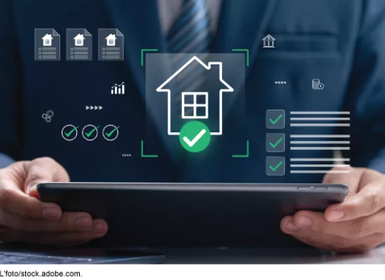 Stock image showing a man holding a computer tablet that has housing icons floating above it.