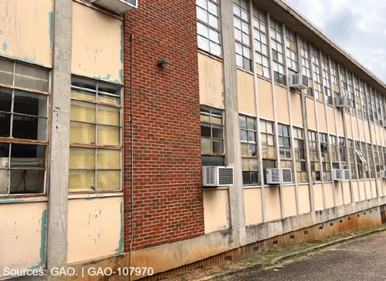 A photo of a school with broken windows and wall air conditioning units.
