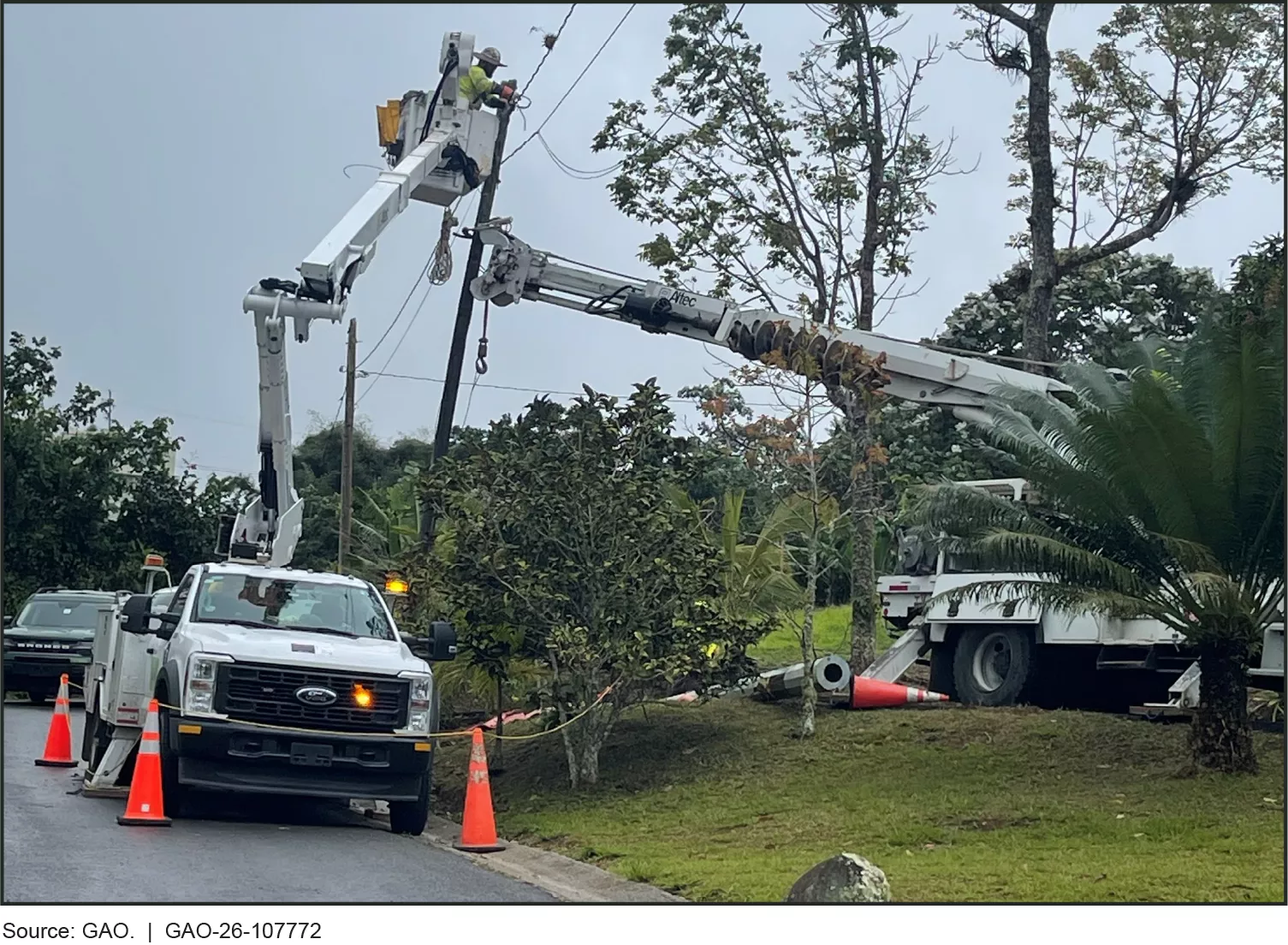 Image shows FEMA-funded Pole Replacement and Streetlight Repair Project in Coamo, Puerto Rico (February 2025). A man is elevated in the bucket of a bucket truck as he repairs powerlines. 