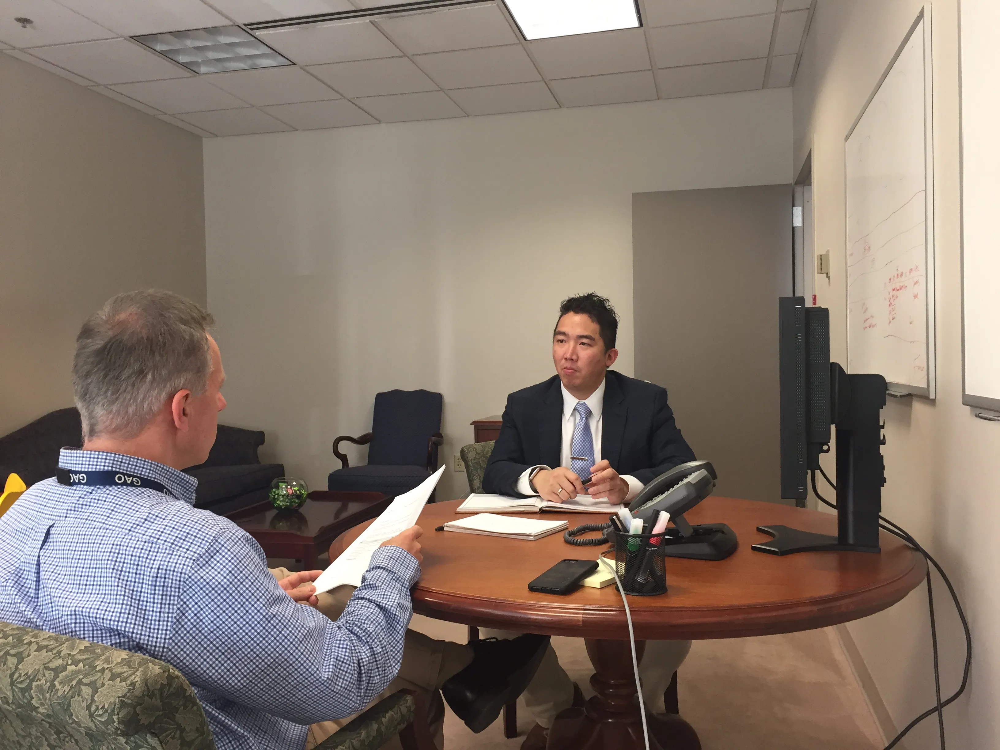 Taka Ariga sits at a small table with another GAO employee