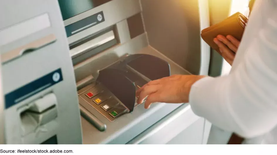 Image of someone taking out money at an ATM
