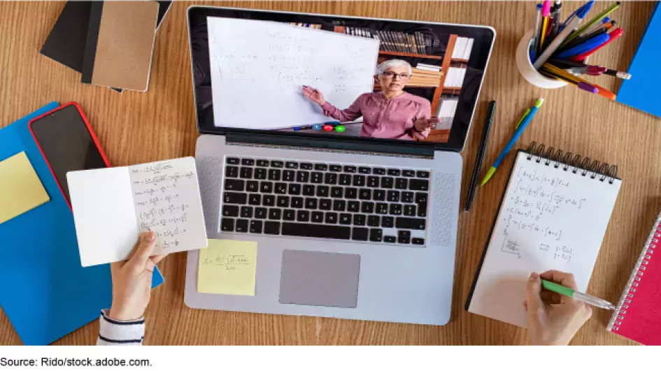 Photo of a laptop with an instructor providing lessons through a video appointment while someone takes notes.