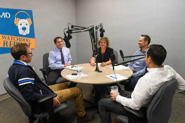 GAO staff around a table recording a podcast