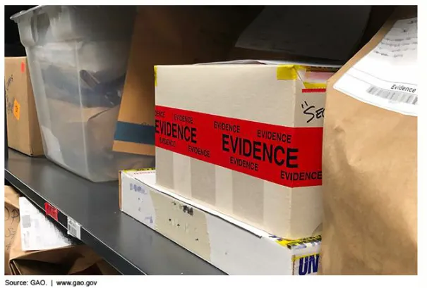 red tape containing the words "evidence" sealing a cardboard box that is sitting on a shelf with other boxes