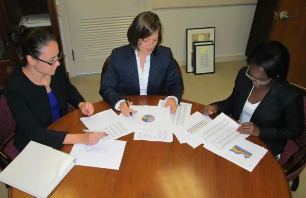 Three GAO interns sitting at a table working together