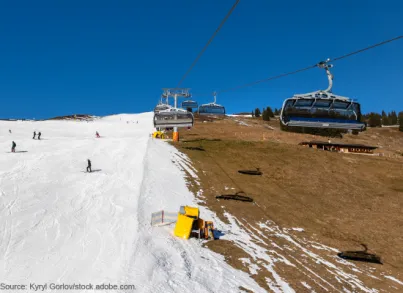 Snow cannons by a ski lift.