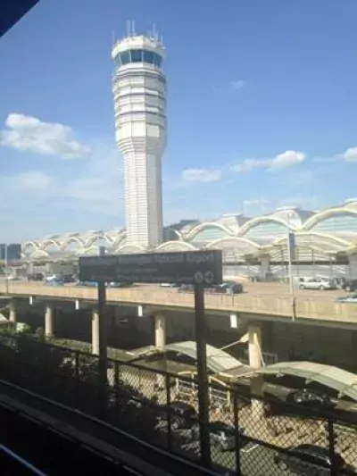 Photo of an airport in the U.S. with air traffic control tower in the background.