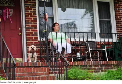 Photo of an older woman sitting on her front porch. 