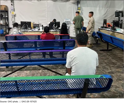 A photo of individuals waiting in a medical tent with CBP personnel.