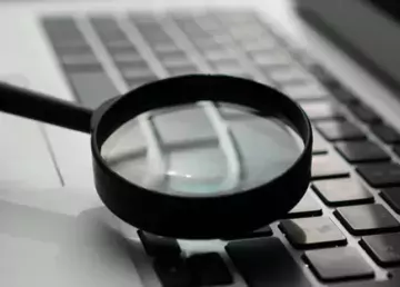 Magnifying glass on laptop keyboard