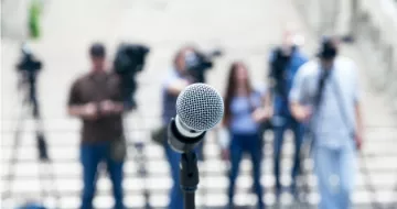 The media standing and waiting for a interview. 