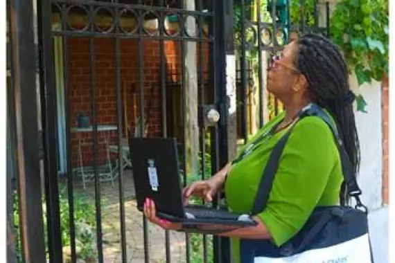 Photo of a Census worker visiting homes.