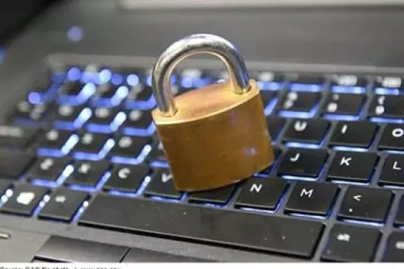 Photo of a padlock on a computer keyboard.