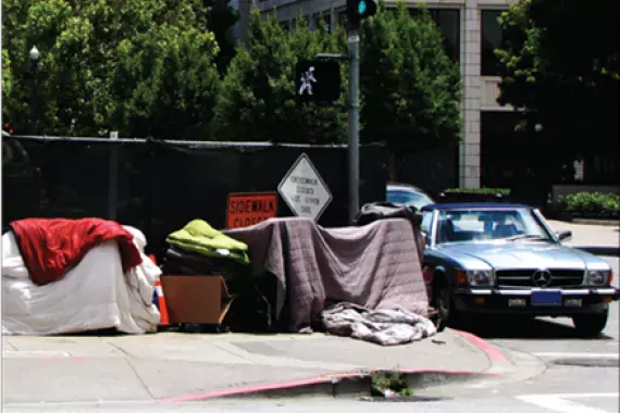 Photo showing shelters created by homeless persons on sidewalk.