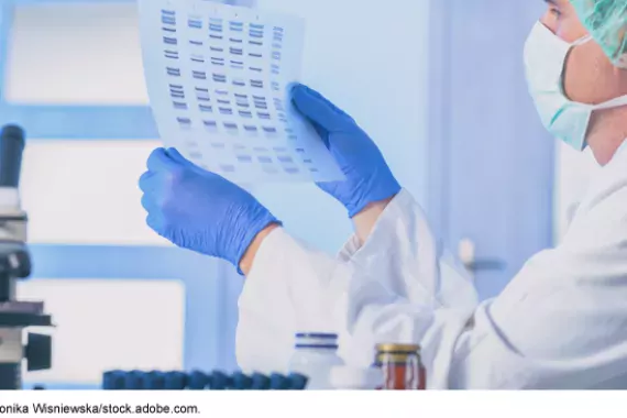 Lab worker holding up a genetic chart