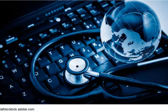 Staged art: A keyboard with a glass globe and stethoscope on it.