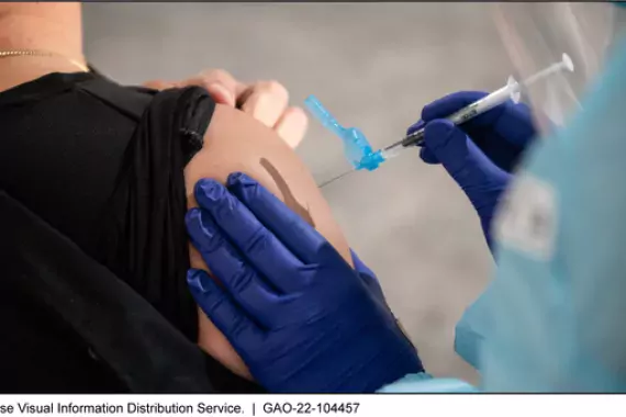 Photo showing a woman receiving a vaccination in her upper arm