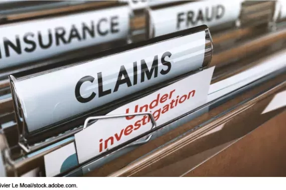 Photo showing a filing cabinet folders marked "fraud," "Insurance," Claims" and "Under Investigation"