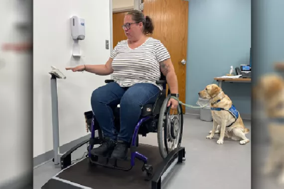 Image of a person using a wheelchair being weighed on a scale specifically made for wheelchair users.