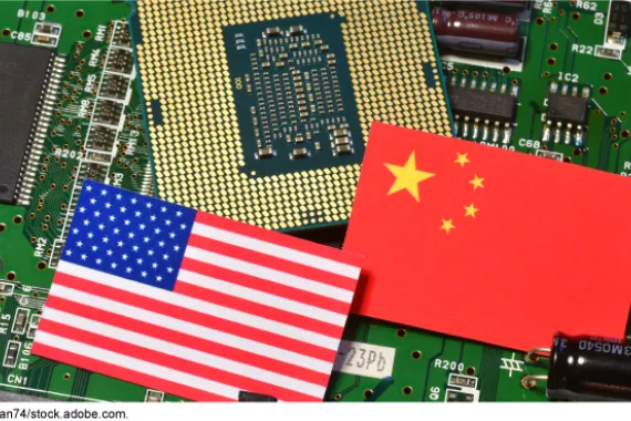 The U.S. flag and Chinese flag lie on top of a computer circuit board. 