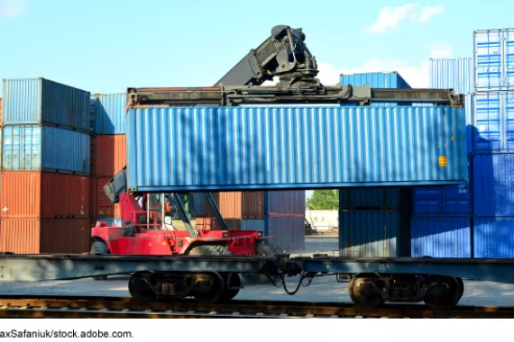 Freight container being loaded onto a train car