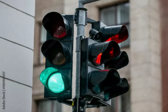 A traffic light at an intersection, green in one direction and red in the other.