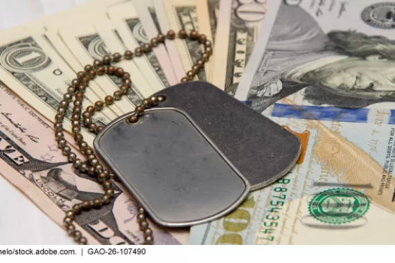  Military dog tags on a chain laying on top of U.S. currency.