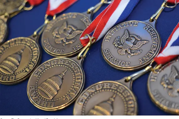 Several Congressional Award medals with striped ribbons.