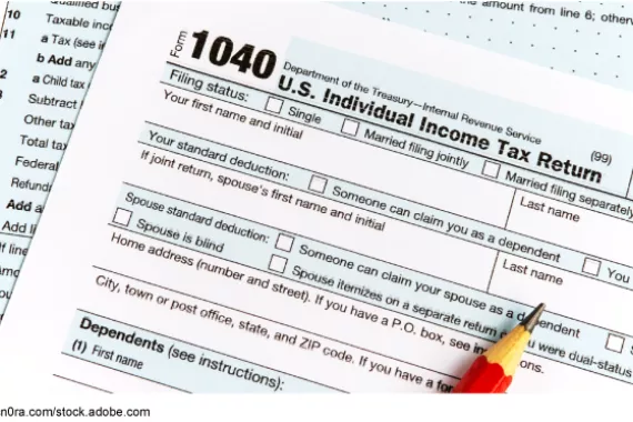 Two pages of a paper copy of the individual tax form 1040 and a pencil.