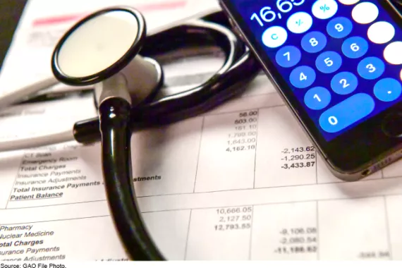 A stethoscope and calculator laying on top of an itemized medical bill