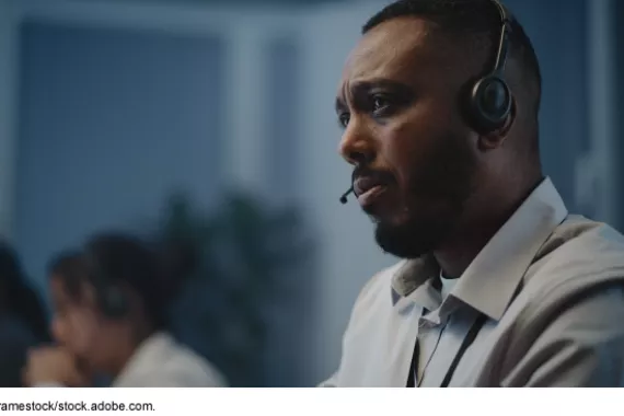 A person with a headset for phone calls looking concerned and listening.