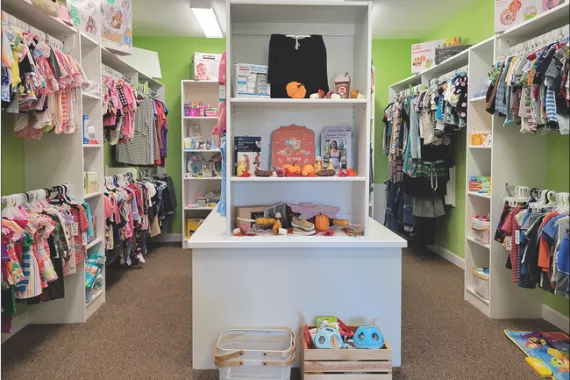 A crisis pregnancy center room with infant supplies, such as clothing, toys, and diapers.