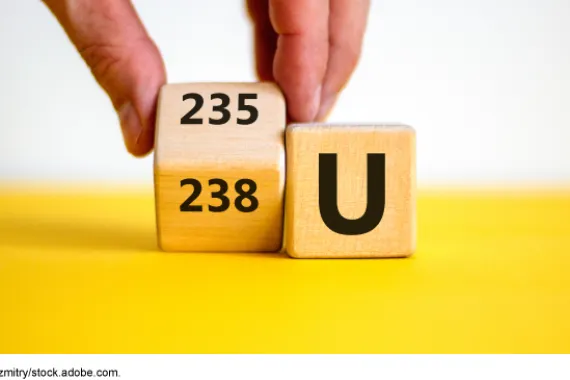 Two wooden blocks. One with the chemical symbol U for uranium; the other with 235 and 238.