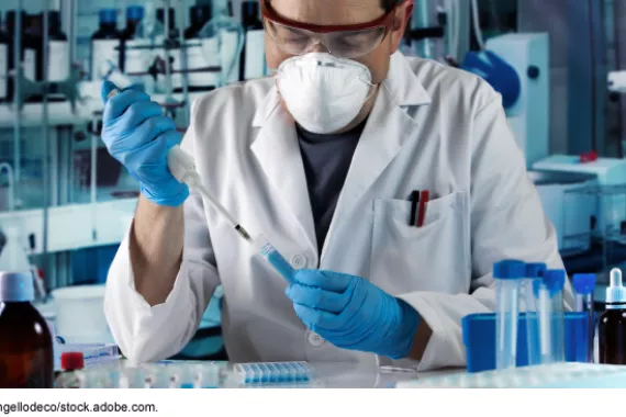 Researcher pipetting test tube to take samples in research laboratory