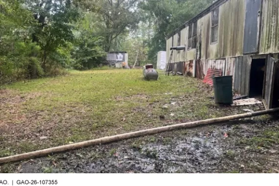 A home with a pipe extending from the foundation that carries untreated wastewater.