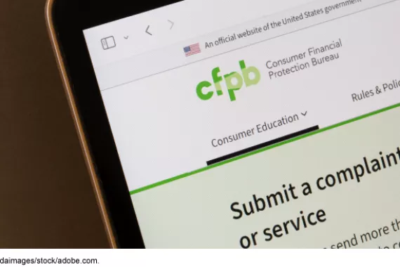 Consumer Financial Protection Bureau web page on a laptop screen, showing consumer education and complaints services.