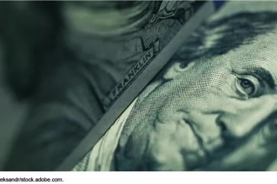 Close-up photo of a $100 bill focused on Benjamin Franklin's portrait. 