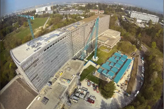 Aerial view of ongoing construction, including cranes and other machinery, at the International Labor Organization's headquarters in Geneva, Switzerland.